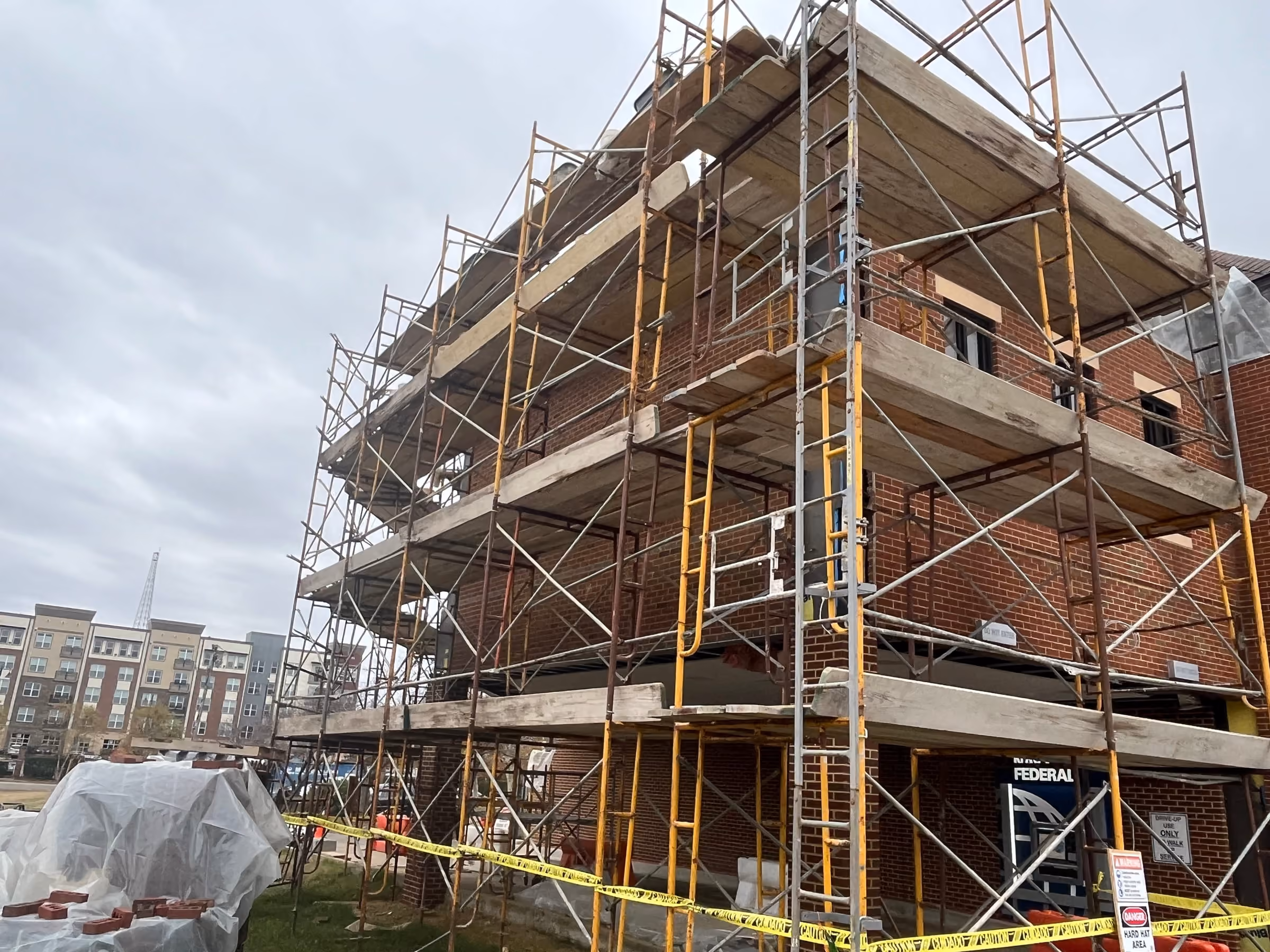 Multi-level scaffolding erected around a brick building undergoing renovation